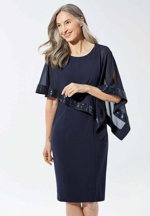 Robe marine avec une superposition en chiffon fluide, dotée d'un ourlet à paillettes et d'une forme évasée. Texture douce avec des manches courtes et amples.