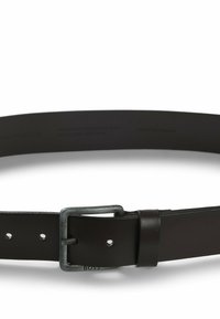 Cinturón de cuero negro con un acabado suave, hebilla de metal en tono plateado y agujeros para ajustes. Presenta un logo de la marca en relieve.