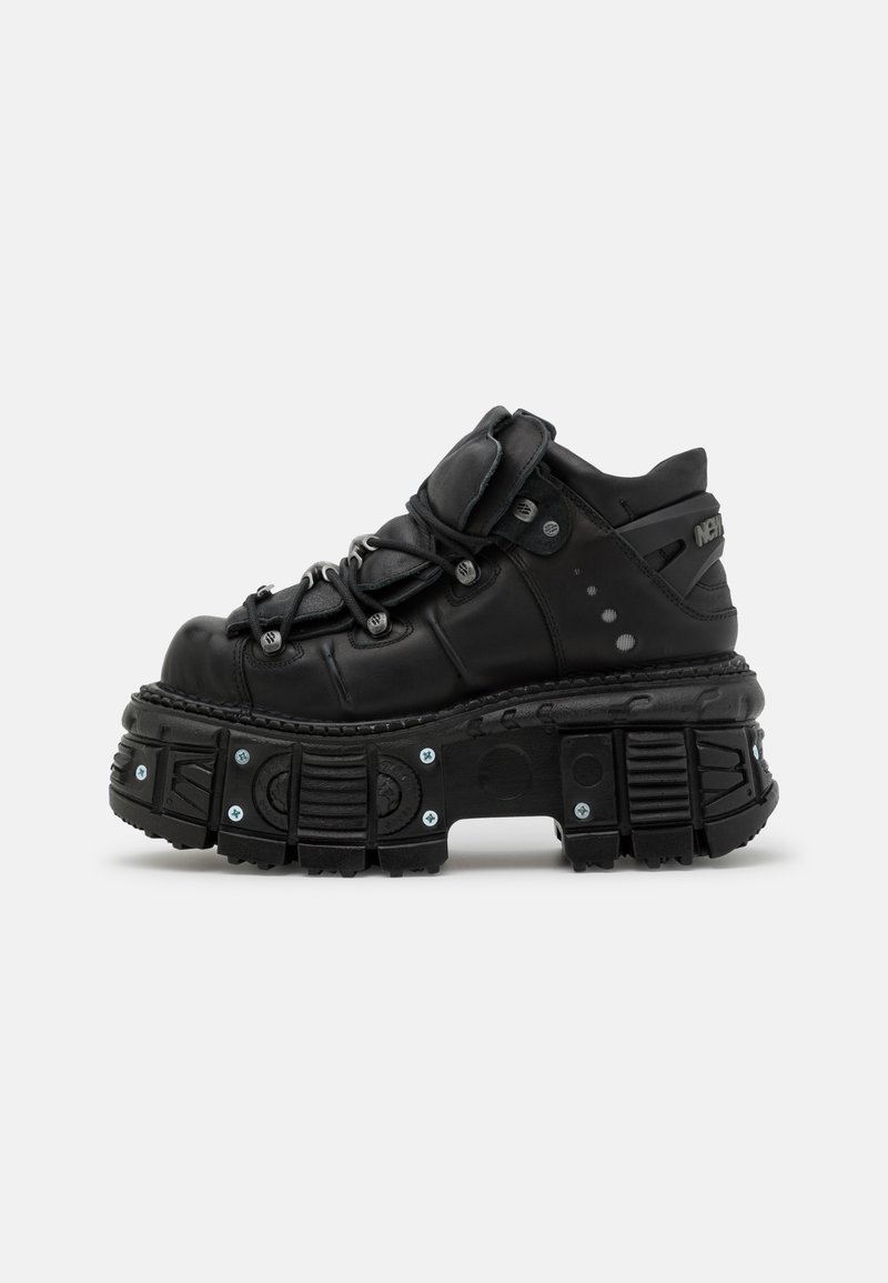Black leather high-top sneaker with a thick rubber sole, lace-up design, padded collar, and metal accents. Features treaded outsole for grip.