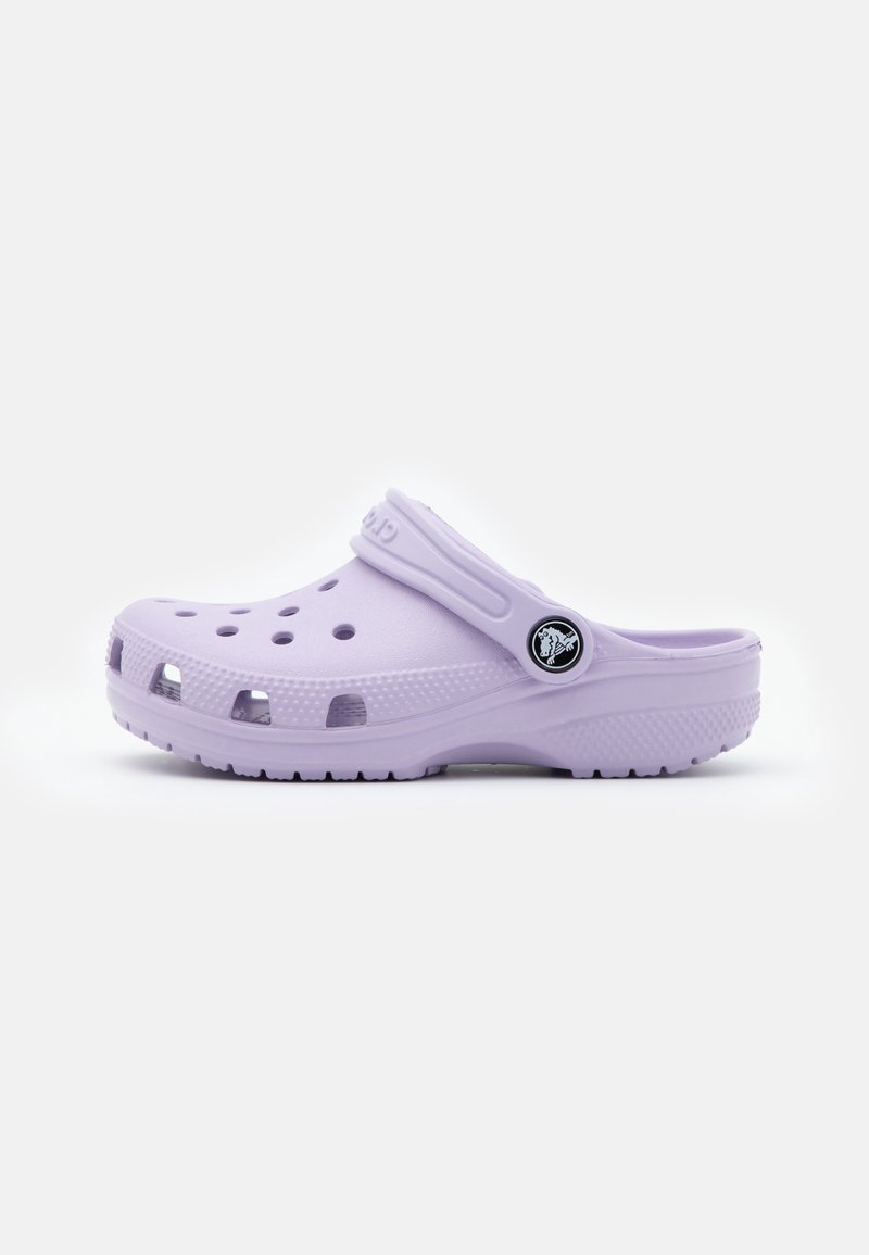 Šviesiai violetinė guminė klumpė, turinti ventiliacijos angas, užsegamą juostelę ir tekstūruotą padą, užtikrinantį sukibimą. Stilingas ir ergonomiškas dizainas.