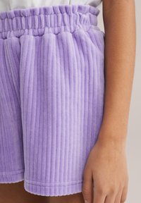 Shorts in velluto a coste viola con texture a righe verticali, vita elastica e orlo cucito. Presentano un tessuto morbido e una vestibilità rilassata.