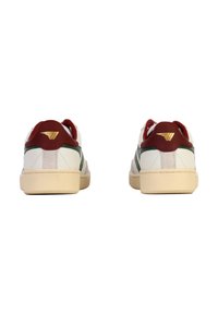 Witte sneakers met rode accenten en groene strepen, voorzien van een gestructureerd leren bovenwerk, een platte vetersluiting en een lichtgekleurde rubberen buitenzool.