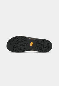 Talpa de pantof de cauciuc negru cu un model hexagonal texturat și un logo galben în centrul său; proiectată pentru aderență și durabilitate.