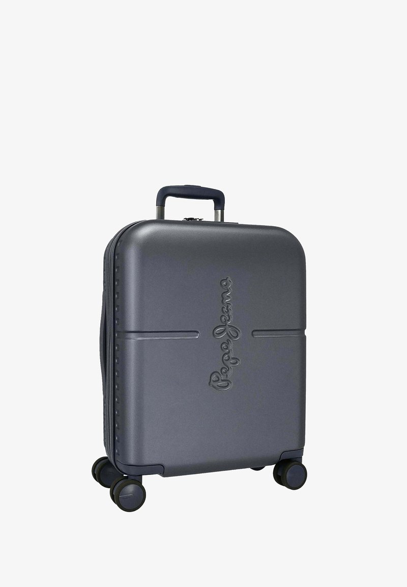 Maleta rígida gris con logo en relieve, mango retráctil y cuatro ruedas para movilidad. Superficie texturizada con líneas sutiles.