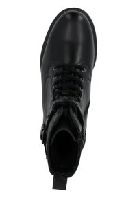 Botín negro de cuero a nivel del tobillo con textura suave, punta redonda y suela duradera. Presenta ojales de metal, cordones y una lengüeta trasera.