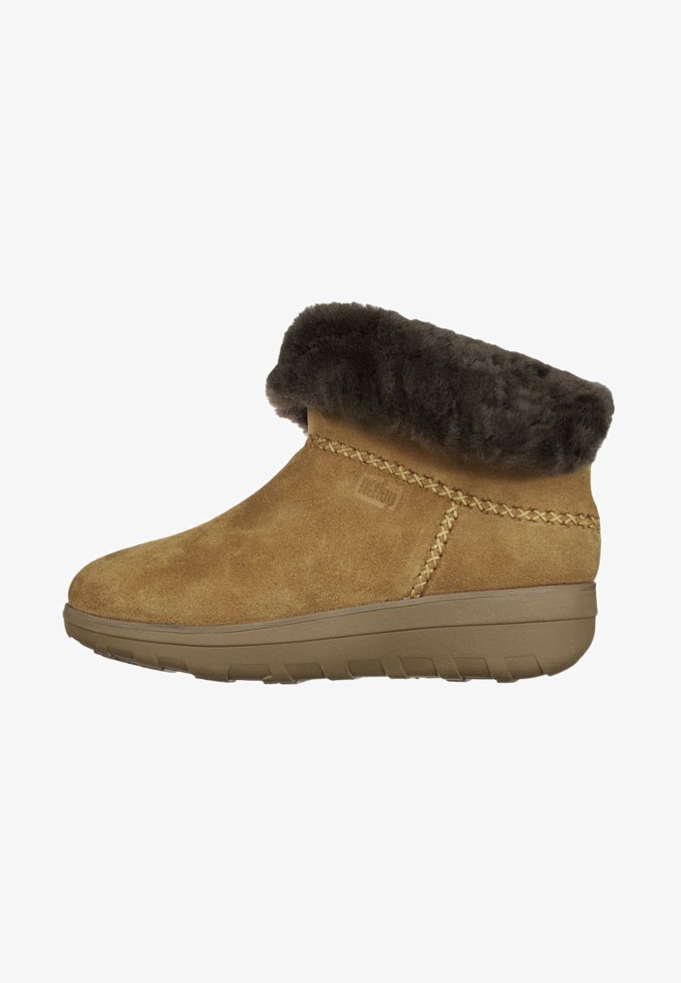 Braune Wildleder-Stiefeletten mit einem lockigen, dunklen Fellbund, gesteppten Details und einer dicken Gummisohle mit strukturiertem Profil für besseren Halt.