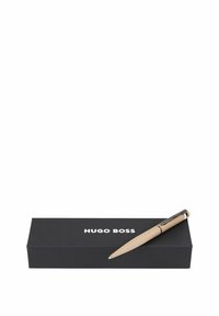 Hugo Boss Kugelschreiber in hellbeige mit einem verchromten Clip, auf einer schwarzen Box mit weißem Logo-Text positioniert.