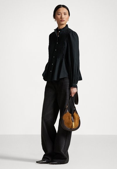 Czarna koszula w kratę z guzikami, z falbaniastym kołnierzykiem i bufiastymi rękawami, w połączeniu z szerokimi ciemnymi spodniami i torbą w dwóch kolorach: brązowym i czarnym.