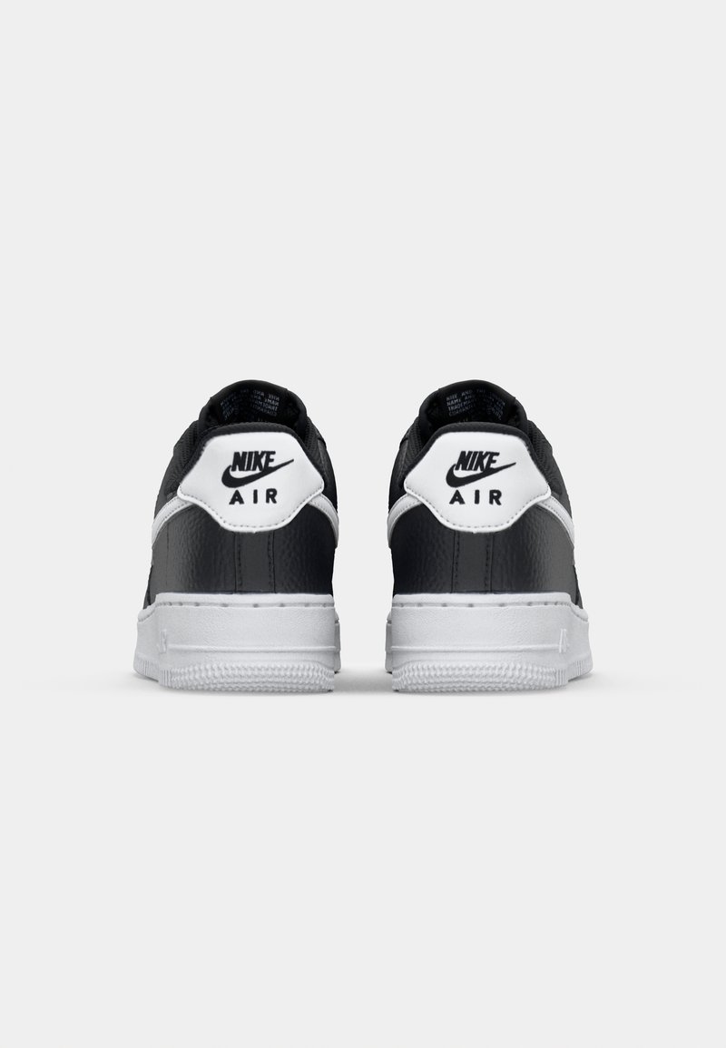 Schwarze Leder-Sneaker mit weißen Akzenten, ausgestattet mit einem strukturierten Obermaterial, gepolstertem Kragen und dem Markenzeichen auf der Ferse. Flache Gummisohle.