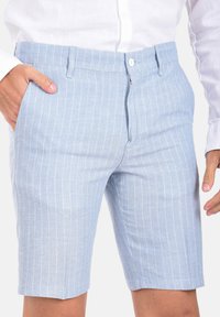 Pantaloni corti a righe azzurri realizzati in un tessuto leggero. Presentano una chiusura con bottone, passanti per la cintura e tasche laterali. Vestibilità aderente con orli rifiniti.