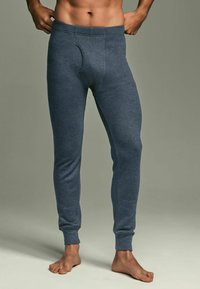 Grå ribbade leggings med en figurnära design, elastisk midja och en horisontell öppning fram. Mjukt, stretchigt tyg.