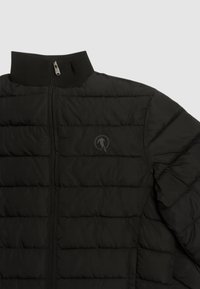 Giacca a vento nera con colletto alto, caratterizzata da cuciture orizzontali, chiusura con zip e un logo discreto sul lato sinistro. Texture liscia.