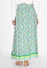 Gonna maxi con motivo floreale in azzurro chiaro, verde e giallo, con vita arricciata e orlo a strati caratterizzato da strisce verdi e gialle.