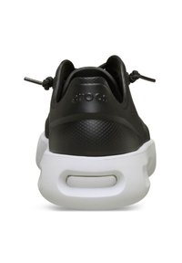 Zapatilla negra con una parte superior de cuero texturizado, una entresuela blanca y cordones para ajustar el fit. Presenta un diseño elegante y una parte trasera redondeada.