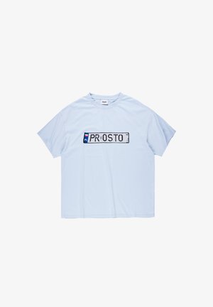 Jasnoniebieska koszulka z krótkim rękawem z prostokątnym nadrukiem na środku, przypominającym zużytą tablicę rejestracyjną z napisami "PL" i "PROSTO".