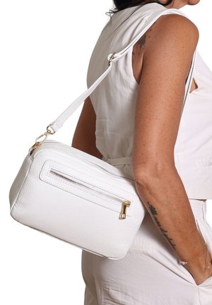 Borsa a tracolla bianca in pelle strutturata con forma rettangolare, dotata di una tasca con zip sul davanti e dettagli in metallo dorato.