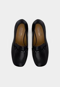 Μαύρα vegan loafers από δέρμα με στρογγυλεμένη τετράγωνη μύτη, διακριτικά ραφάκια και διακοσμητικό λουράκι με αγκράφα. Λείο υφή.