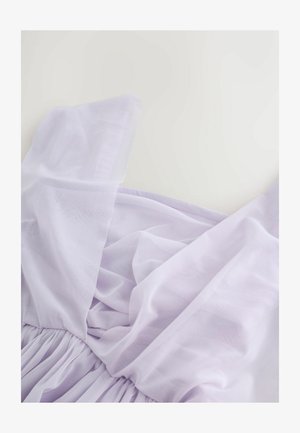 Lavandas krāsa kleita ar slāņotu, caurspīdīgu dizainu, plisuātu svārku un plašām, pieguļošām lencītēm. Materiāls šķiet viegls un teksturēts.