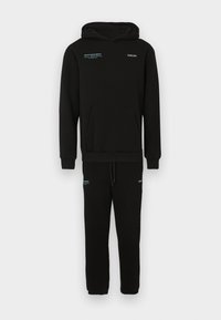 Conjunto de sweatshirt e calças de fato pretas em tecido de mistura de algodão. Apresenta um bolso canguru, cintura com cordão e realces de texto azul contrastante.