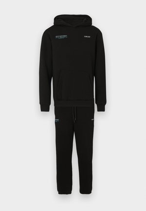 Sæt bestående af sort hættetrøje og sweatpants lavet af en bomuldsblanding. Har en kengurulomme, talje med snøre og kontrasterende blå tekst accenter.