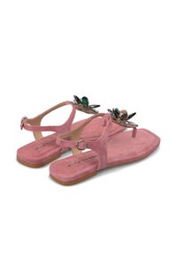 Sandali in suede rosa con decorazioni floreali, suola piatta, cinturino alla caviglia e dettaglio della fibbia. Texture liscia e design open-toe.