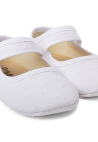 Pantofi Mary Jane din bumbac alb, cu două barete elastice, vârful rotund neted și un model texturat cu puncte pe partea superioară.