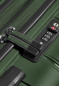 Valigia dura verde con superficie texturizzata, doppie zip contrassegnate "REDOLZ", lucchetto a combinazione e angoli protettivi.