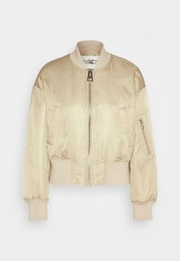 Veste bomber en satin beige avec col, poignets et ourlet côtelés, fermeture éclair à l'avant, deux poches pour les mains et une poche zippée sur la manche gauche.