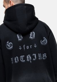 Felpa nera con cappuccio caratterizzata da un grande testo grigio a contrasto sul retro, che recita "DIO per NULLA", con una vestibilità comoda e un cappuccio a collo alto.