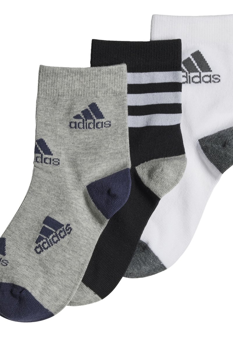 Tres pares de calcetines: grises con talón oscuro, negros con rayas blancas y blancos con talón gris. Cada uno presenta el logo de Adidas.