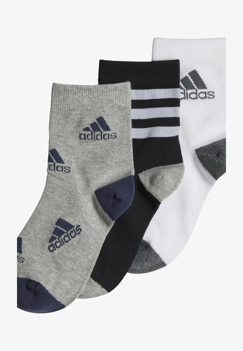 Tres pares de calcetines: grises con talón oscuro, negros con rayas blancas y blancos con talón gris. Cada uno presenta el logo de Adidas.