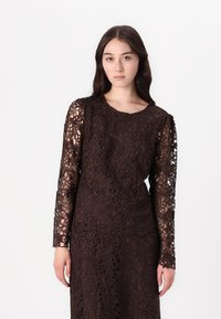 Braunes Spitzenkleid mit langen Ärmeln und floralem Muster, mit Rundhalsausschnitt und taillierter Silhouette, die aufwändige Details zeigt.