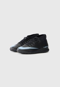 Mustad mustandjalatsid peene disainiga, millel on helesinine Nike'i logoga kaar ja tekstureeritud kummist tallad. Keskmise kõrgusega mudel paeltega.