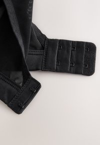 Zwarte beha-band met gaas- en elastisch materiaal, voorzien van haak-en-oogsluitingen voor verstelbaarheid. Soepele textuur met gestikte randen.