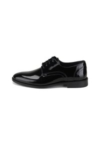 Chaussure de ville pour homme en cuir verni noir avec un laçage fermé et un talon bas empilé, présentée en profil droit sur fond blanc.