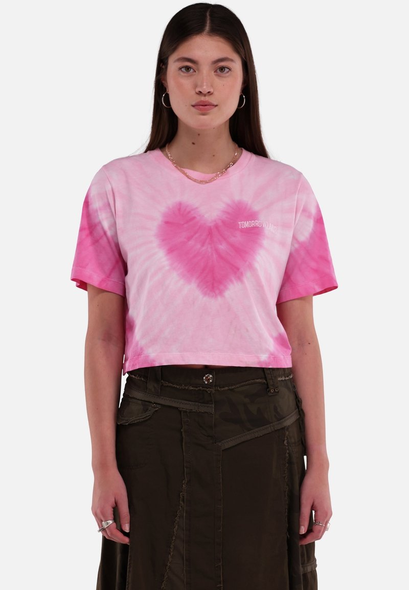 Roze tie-dye crop t-shirt met een hartpatroon in het midden en de tekst "TOMORROW" in het wit. Korte mouwen en een ontspannen pasvorm.