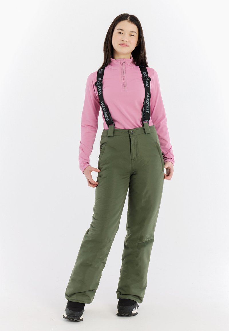 Lichte roze lange mouw top en groene skibroek met verstelbare zwarte bretels. De broek heeft een gladde textuur en een ontspannen pasvorm.
