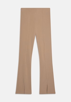 Pantalons évasés beiges en tissu texturé, avec des détails de coutures verticales et des fentes au bas pour un design supplémentaire.