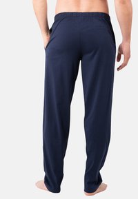 Pantalons légers bleu marine, coupe décontractée, avec une taille élastique et des poches latérales, fabriqués en tissu doux.