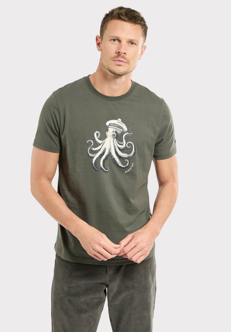 T-shirt en coton vert olive avec un motif détaillé d'un pieuvre en blanc et bleu, encolure ronde et manches courtes.