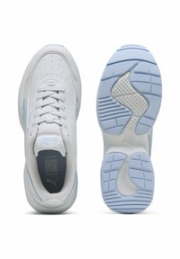 Sneakers bianche con tomaia in pelle liscia, dettagli blu, chiusura con lacci e suola in gomma testurizzata con un design ondulato e modelli di presa.