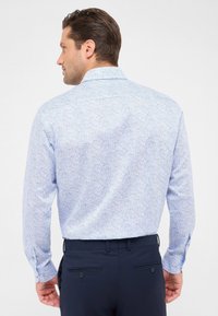Camicia a manica lunga di colore azzurro chiaro con motivo paisley. Collo a camicia con bottoni, polsini con un bottone e vestibilità slim. Tessuto dal texture morbida.