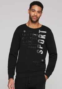 Sudadera negra de mezcla de algodón, con texto gráfico en diferentes fuentes y tamaños en el frontal, escote redondo y puños acanalados.