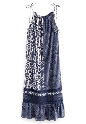 Ærmeløs kjole med marineblå og hvide abstrakte og blomsteragtige mønstre, justerbare skulderstropper med bindebånd og blonderkant over flæsekanten.