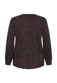 Blouse à manches longues avec un fond noir et un motif floral bordeaux. Dotée d'un col rond et de poignets froncés. Fabriquée en tissu doux.