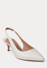 Bela usnjena ženska čevlja z nizkim petkom in naramnicami, z ostrim koničastim prstom ter bež notranjo oblogo na belem ozadju.