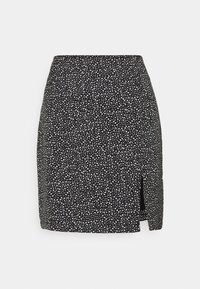 Černá mini sukni s nepravidelným bílým tečkovaným vzorem a malým bočním rozparkem na jednobarevném pozadí.