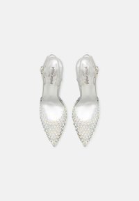 Escarpins slingback métalliques argentés à bouts pointus, ornés de clous irisés sur le devant, dotés d'une fine bride autour de la cheville.