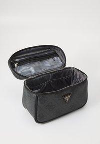 Crna sintetička kozmetička torba s zatvaranjem na zip, sivi unutrašnji oblog, više pretinaca i trokutasti metalni logo kao dekoracija.