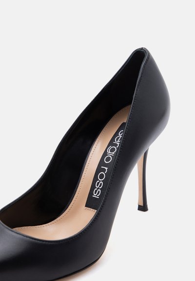 Μαύρο δερμάτινο γόνατο με ψηλή γόβα, μυτερή μύτη και μπεζ εσωτερική επένδυση, με ετικέτα "Sergio Rossi" στο εσωτερικό.